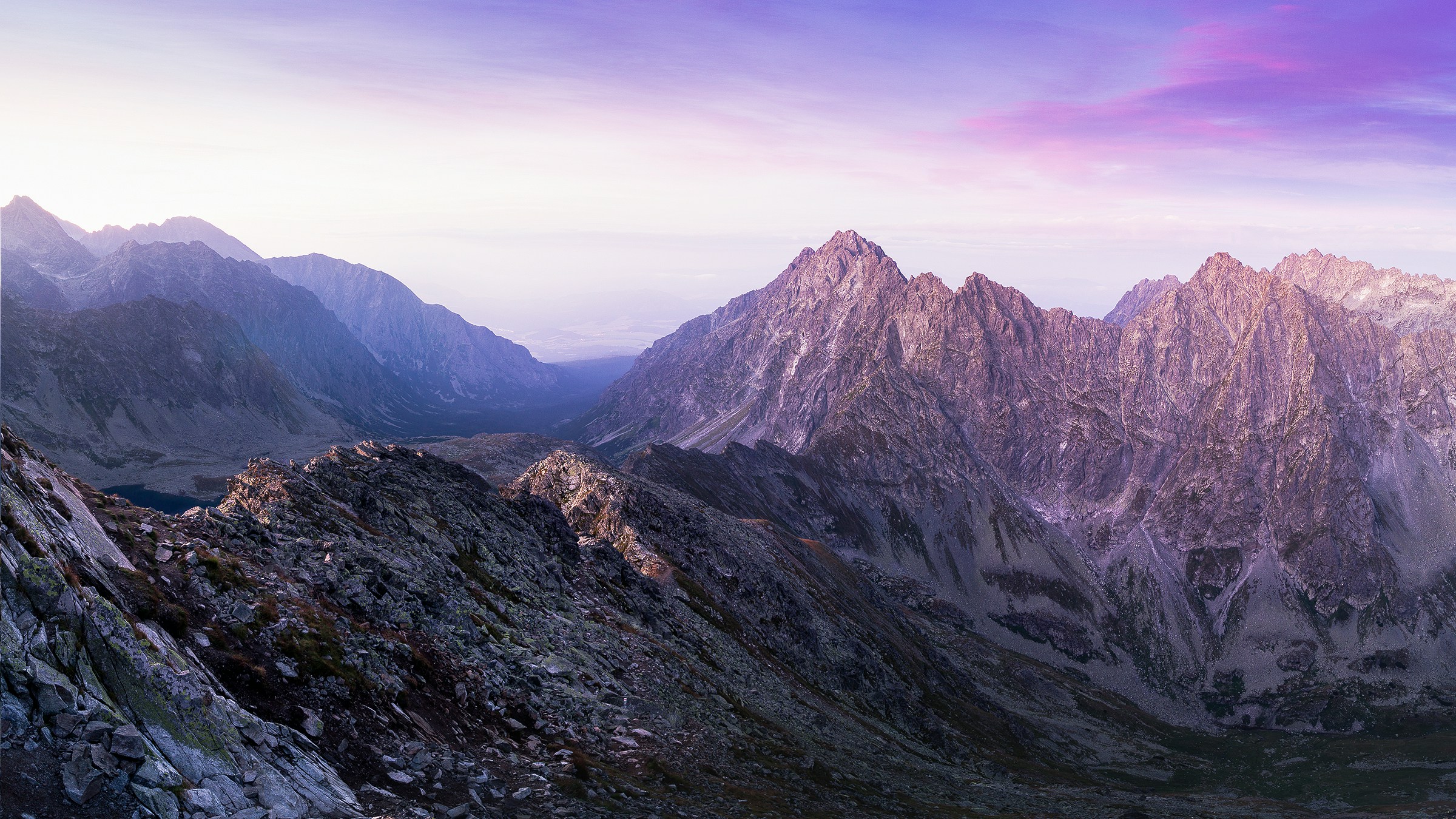 A rocky mountain range under a purple-coloured sky